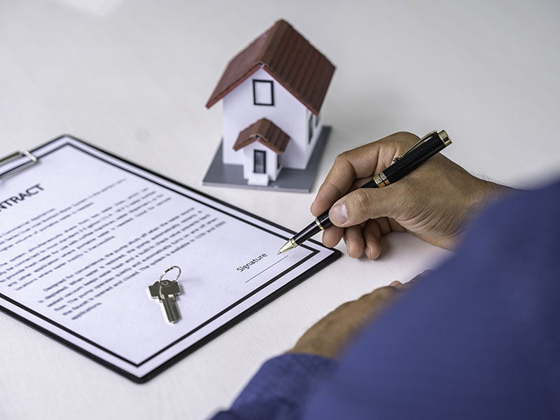 businessman-signing-a-document-or-application-form-Real Estate Conveyancing