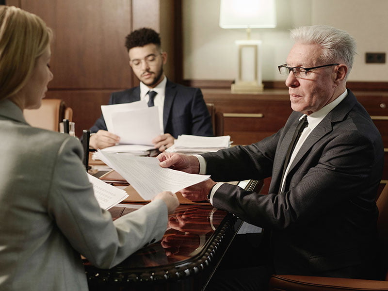 group-of-business-people-doing-paperwork-sitting-Lawyer Vs Notary-Real Estate Transactions