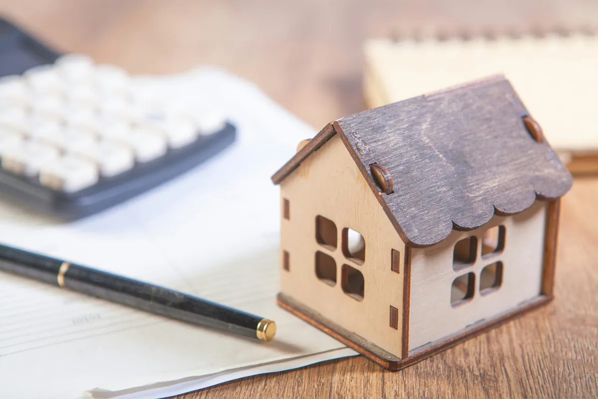 House model with a calculator and notebook