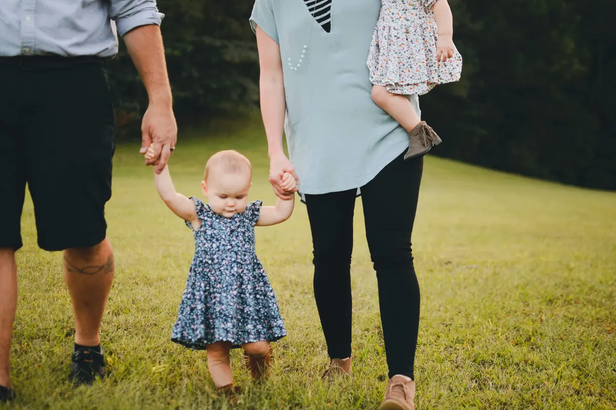 Family walking together on a grassy field
