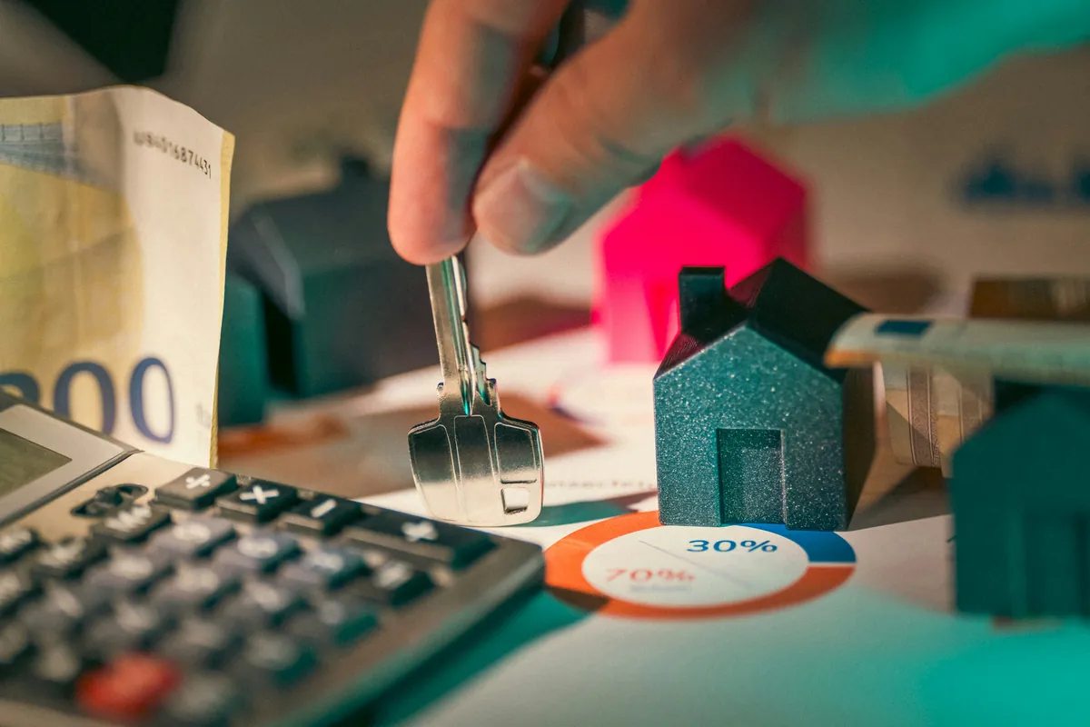 Navid Hakimi Group GST on New Homes in BC | First-Time Buyer Rebate Guide 2 Hand holding a key above small house models
