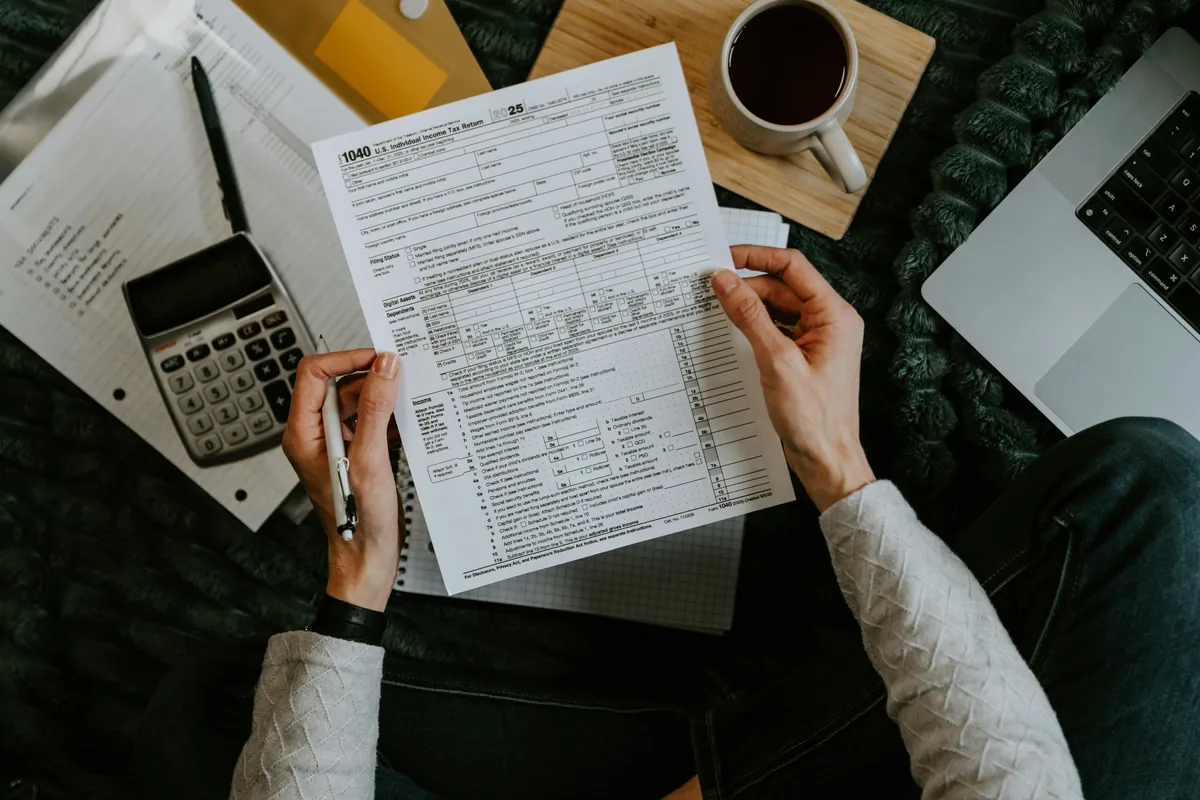 Navid Hakimi Group GST on New Homes in BC | First-Time Buyer Rebate Guide 3 Tax forms with a calculator and laptop