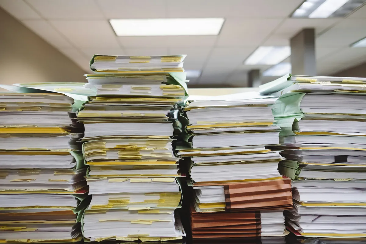 Stacks of paper records and file folders