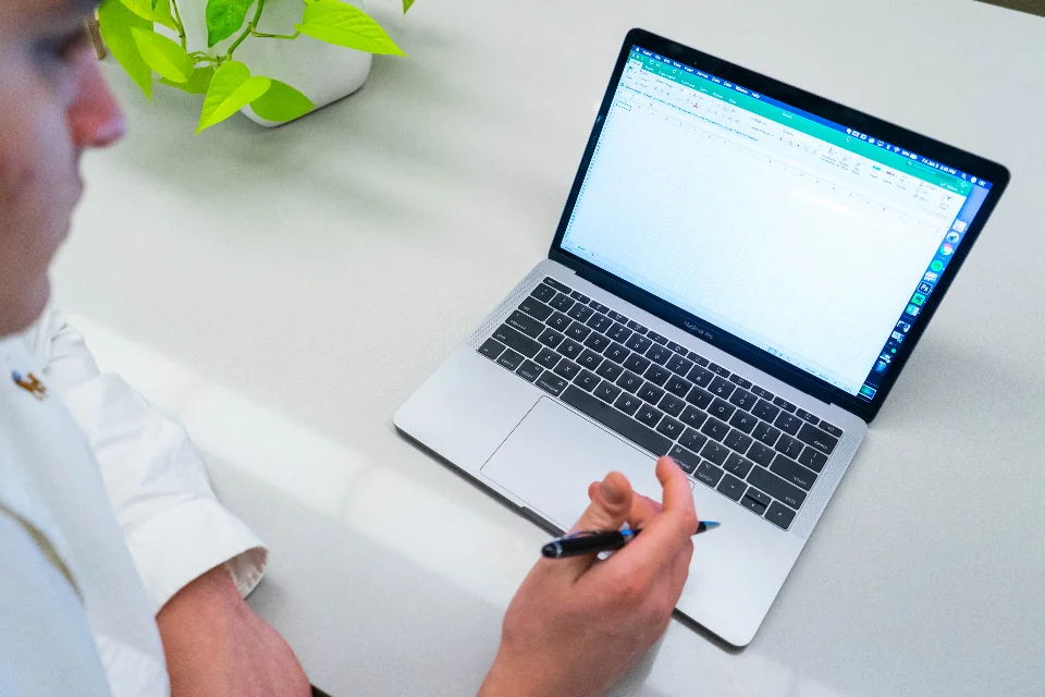 Laptop and pen on a desk while completing an online application
