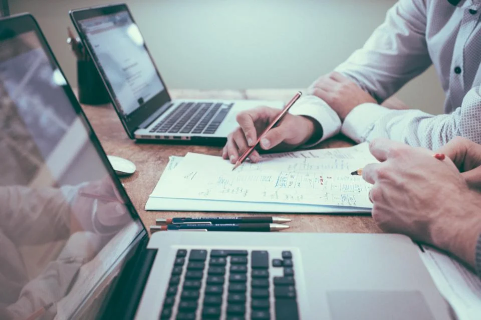 Investor working through commercial mortgage numbers on a laptop and notepad