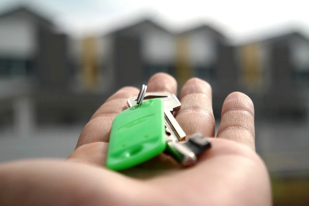 Navid Hakimi Group Buying a Duplex in North Vancouver | Side-by-Side vs Up/Down vs Strata 2 Hand holding house keys in front of a multi-unit home