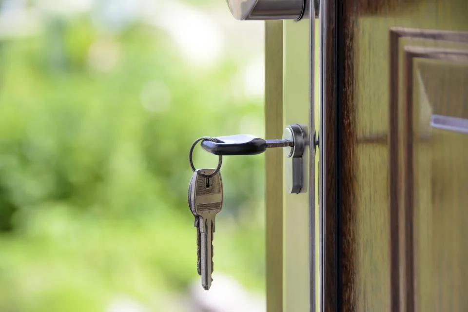 Key in the lock of an open front door on completion day