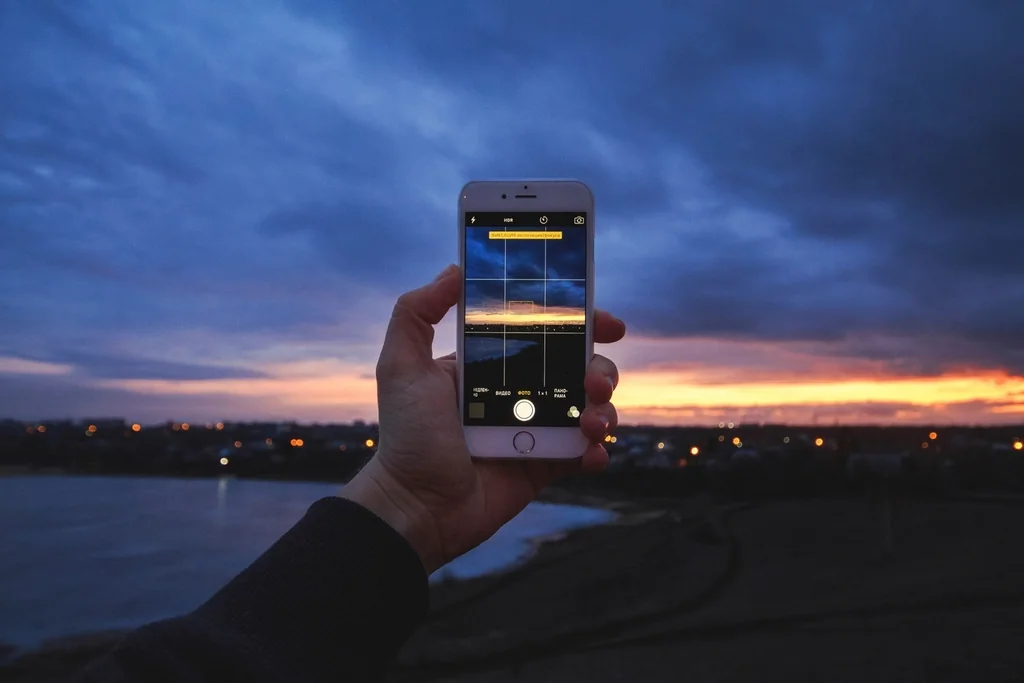 Navid Hakimi Group Why Is My House Not Selling? 9 Reasons and How to Fix Them 1 Taking a photo with a smartphone at sunset