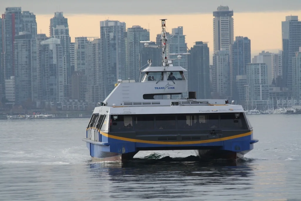 Navid Hakimi Group Living in Lower Lonsdale | A Buyer's Guide to North Vancouver's Waterfront Core 1 SeaBus passenger ferry crossing the harbour in front of the downtown Vancouver skyline