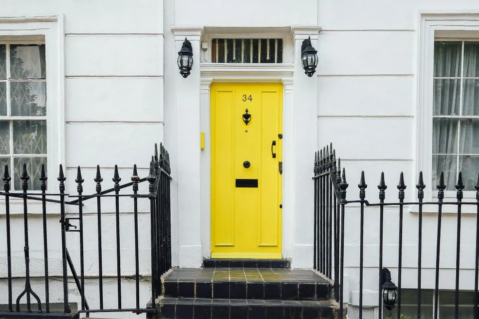 Navid Hakimi Group How to Sell Your House Fast in Vancouver | 5 Options Compared 1 Bright yellow front door of a white townhouse