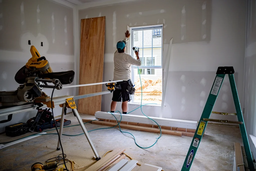 Contractor renovating a room with fresh drywall and new windows