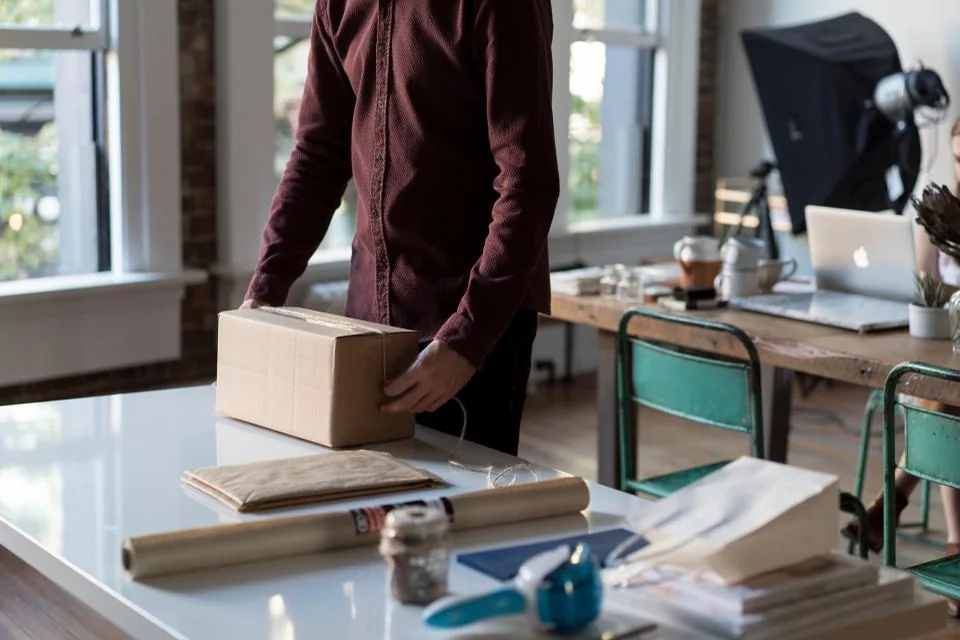 Person packing a cardboard box before moving out