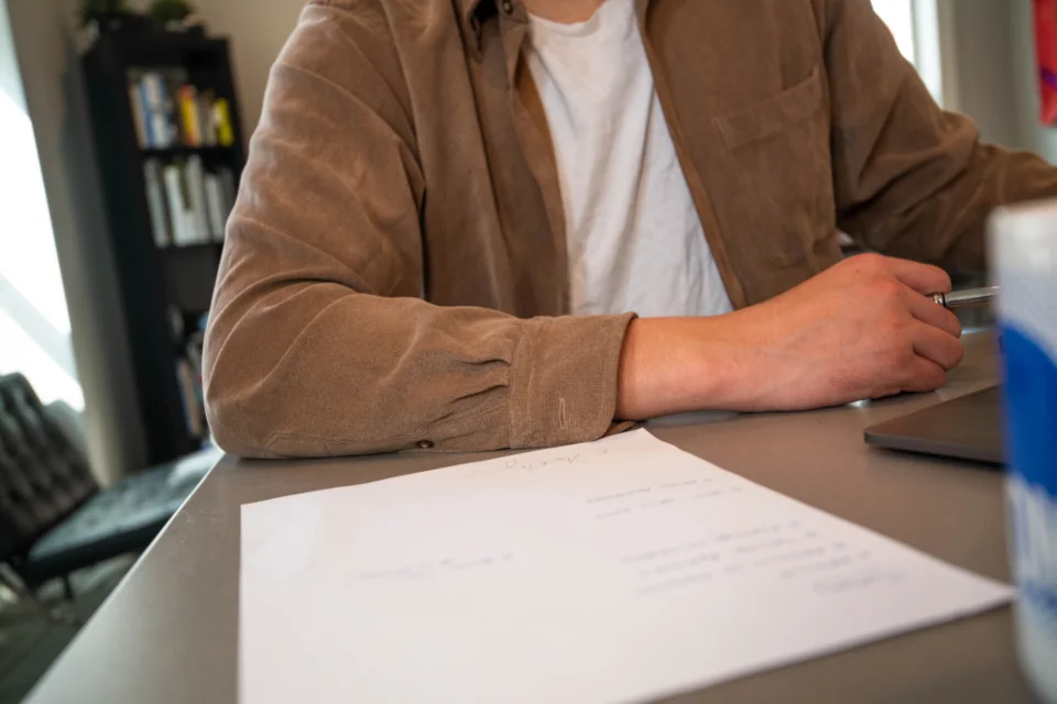 Navid Hakimi Group North Vancouver Townhouses | Prices, Best Areas and What to Check 3 Buyer reviewing strata documents at a desk before removing subjects